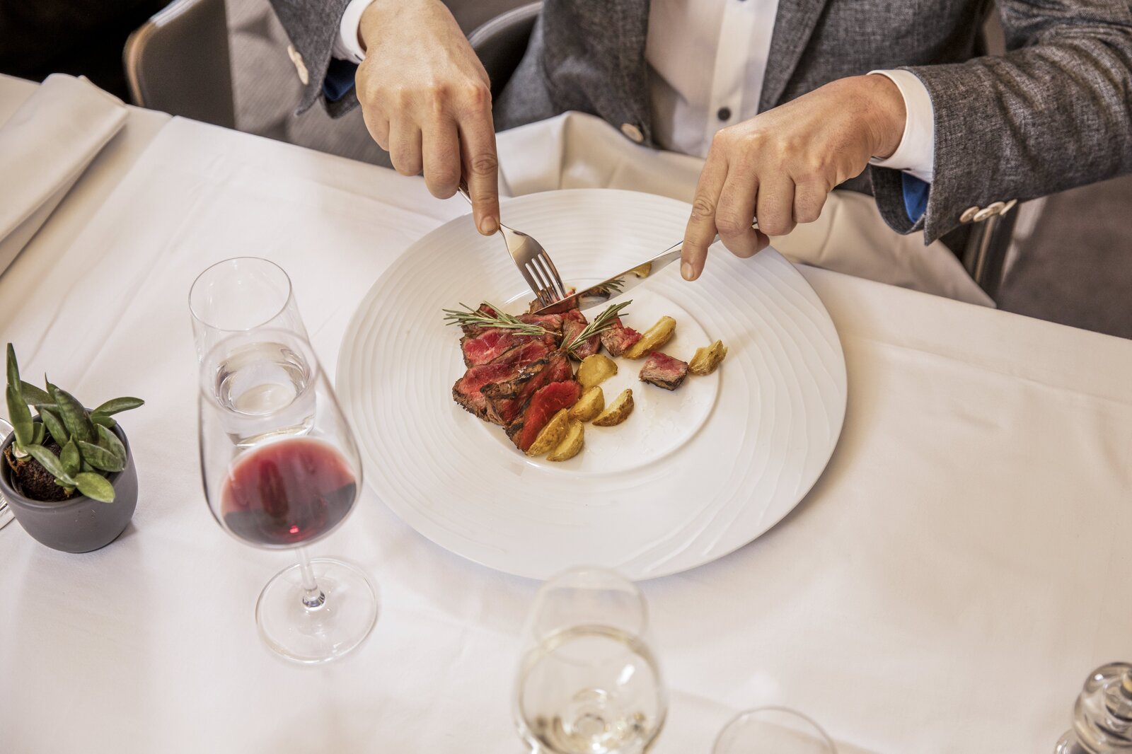 Elegante Männer geniessen ein Dinner in Locarno und lassen sich von einem köstlichen Fleischfest verwöhnen begleited mit einem passenden Rotwein.